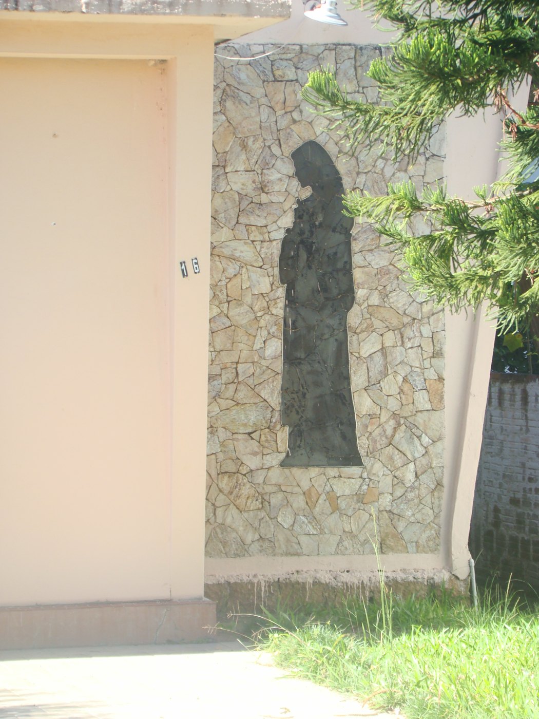 Painel em basalto na fachada, com a silhueta de Santa Teresinha.